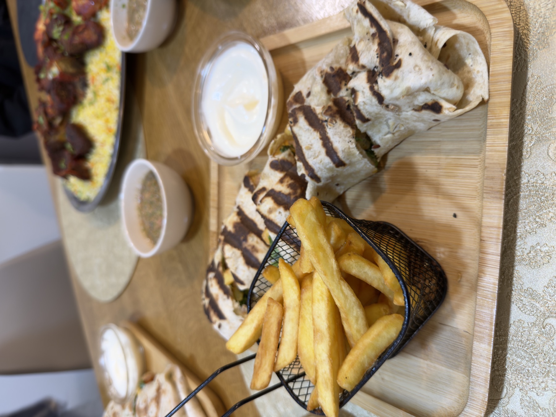 Table avec wraps grillés, frites et sauces